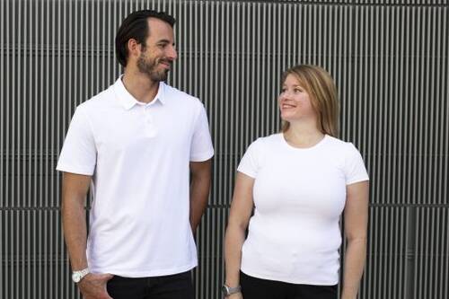 Imagen de dos personas mirándose y que visten alguno de los modelos que ofrecemos de Ropa Corporativa.